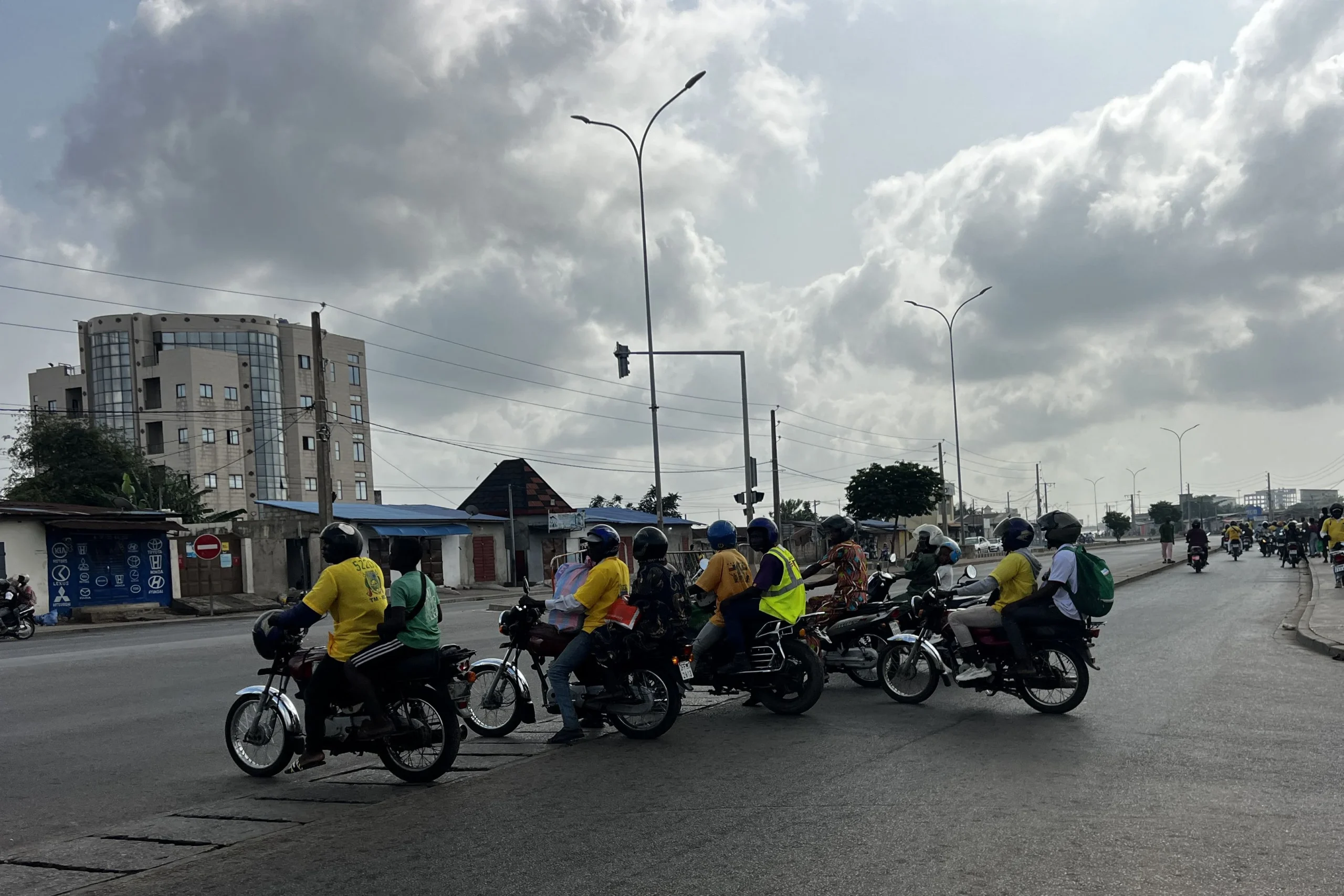 Motorbike taxis transporting passengers at a Cotonou intersection amid rumors of a potential coup in Benin