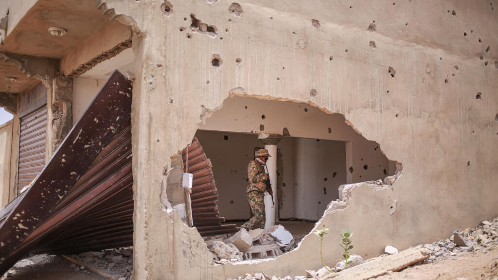 A soldier from the National Liberation Front of Azawad (FLA) walks through a damaged building in Kidal on May 9, 2026.