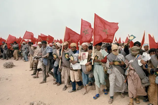 Moroccan civilians during the 1975 Green March, carrying flags and portraits of King Hassan II
